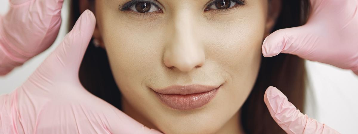 Hands in gloves on face undertaking treatments